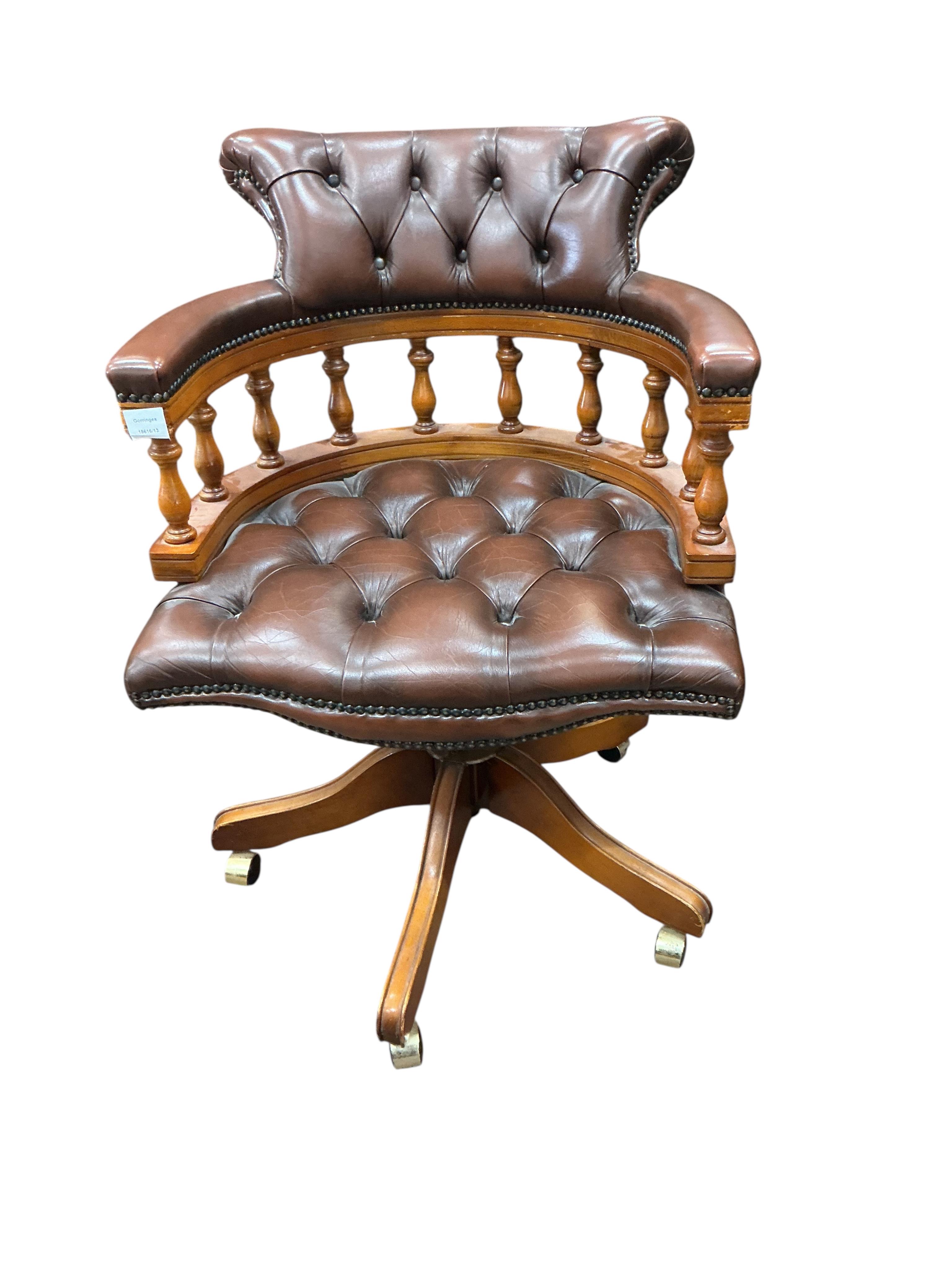 A reproduction mahogany and buttoned brown leather swivel desk chair, width 61cm, height 88cm
